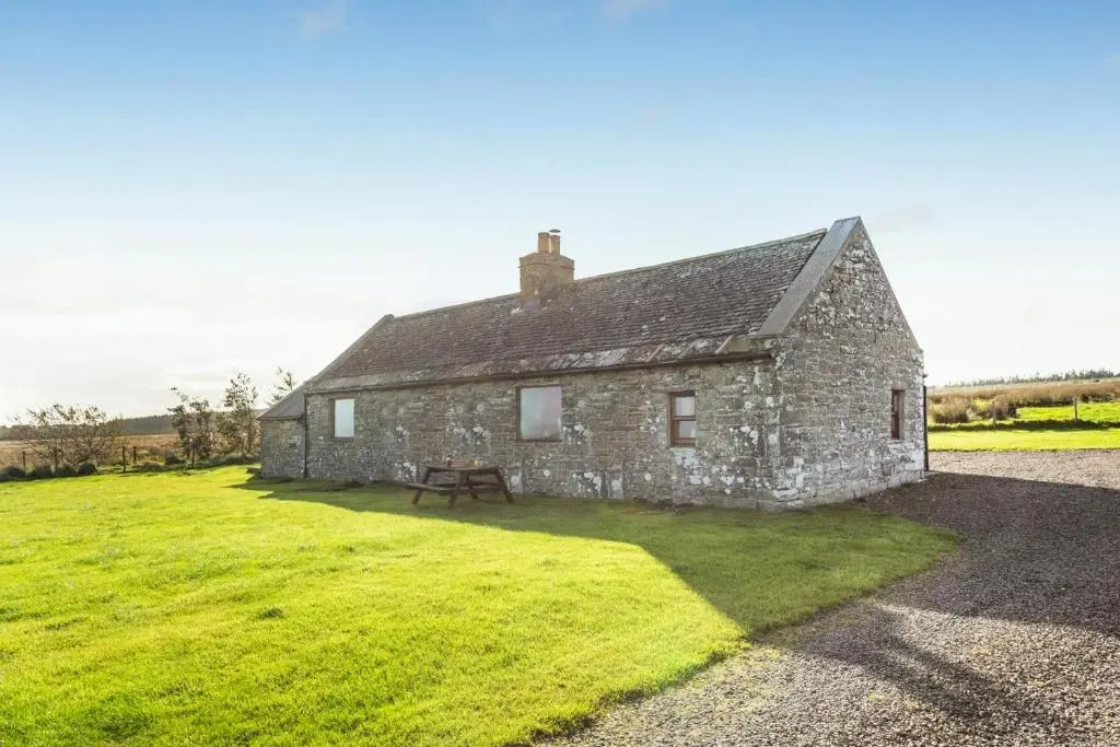 an old stone house with a bench in a field at 1 Bed in Wick oc-b33442 in Wick