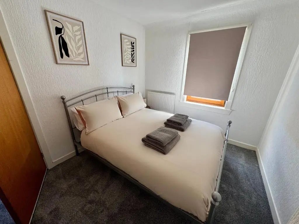 a bedroom with a bed with two towels on it at Bruce Gardens Home in Inverness