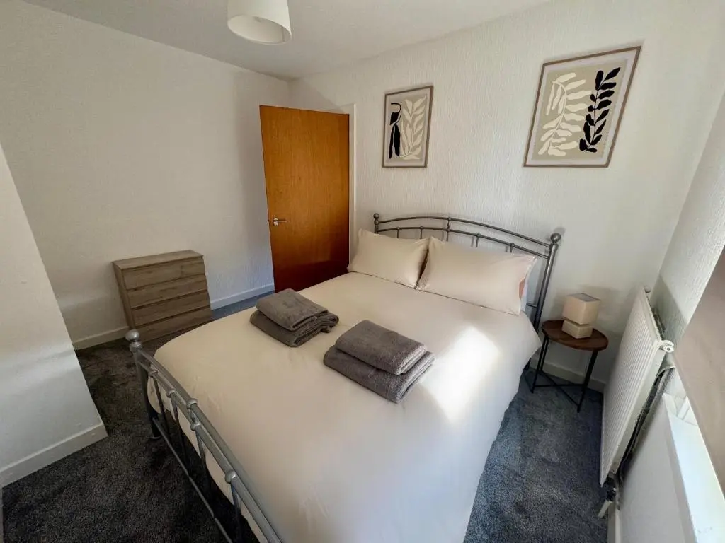 a bedroom with a white bed with two pillows on it at Bruce Gardens Home in Inverness