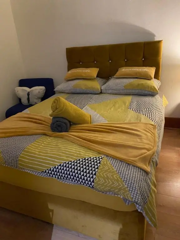 a large bed with yellow and blue sheets and pillows at Cozy one bedroom apt in Inverness