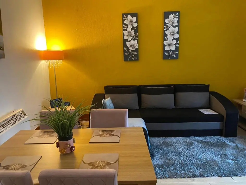 a living room with a couch and a table at Cozy one bedroom apt in Inverness