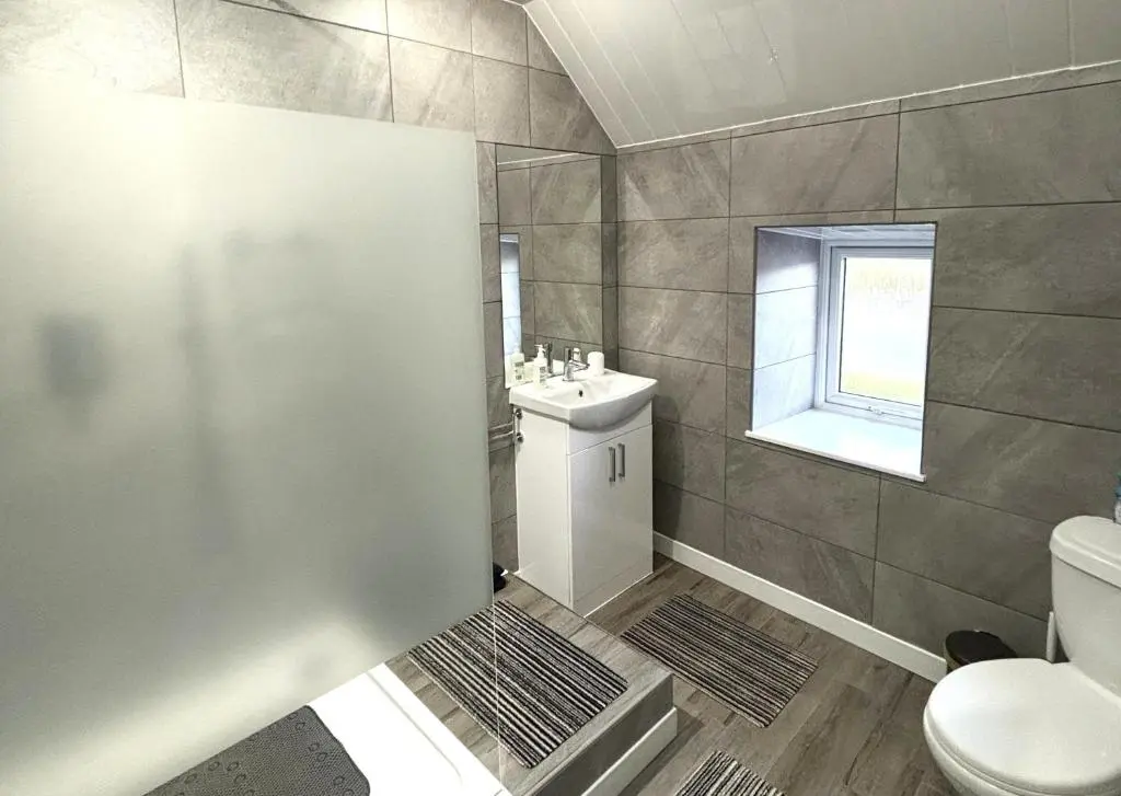 a bathroom with a toilet and a sink at Smiddy Cottage in Portmahomack