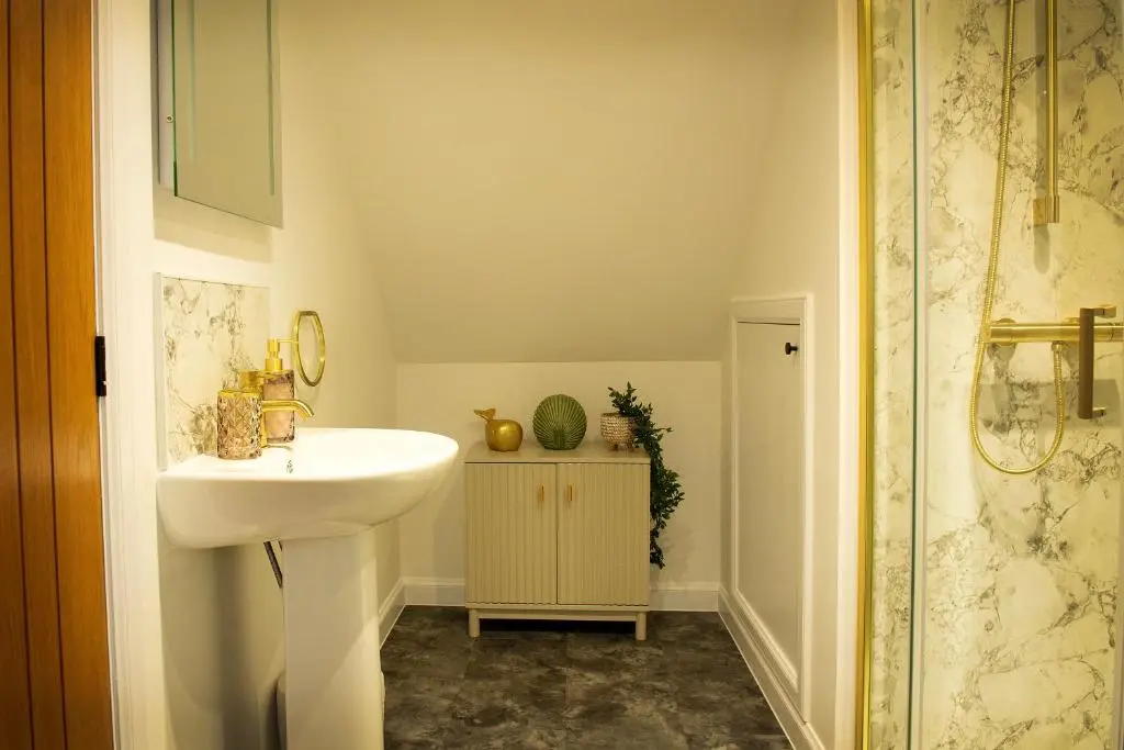 a bathroom with a sink and a shower at Coorie-In Cottage in Whitehills