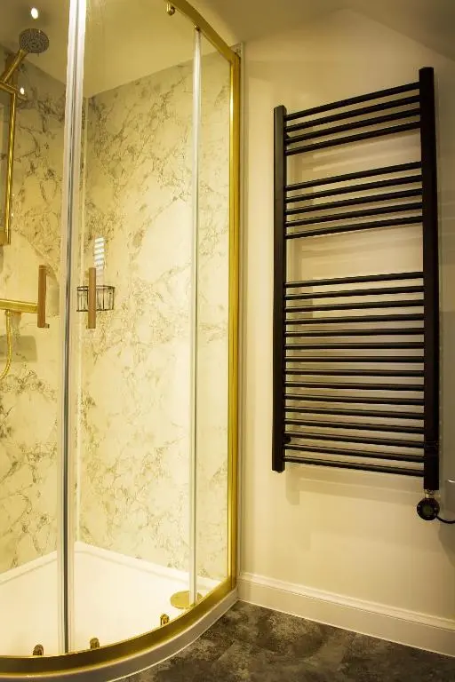 a bathroom with a shower with a glass door at Coorie-In Cottage in Whitehills