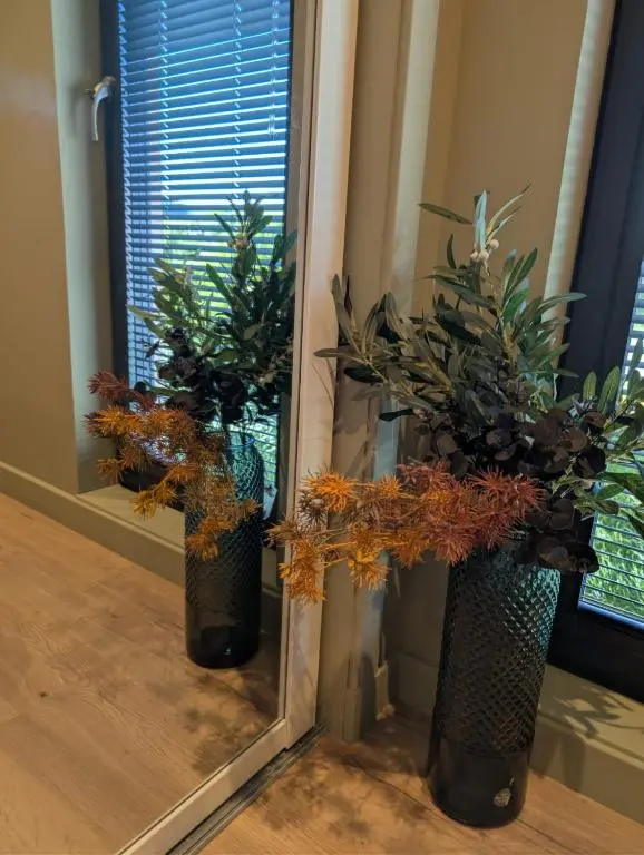 two vases with flowers inront of a mirror at Luxury Lodge by Findhorn Sands No 18 in Findhorn