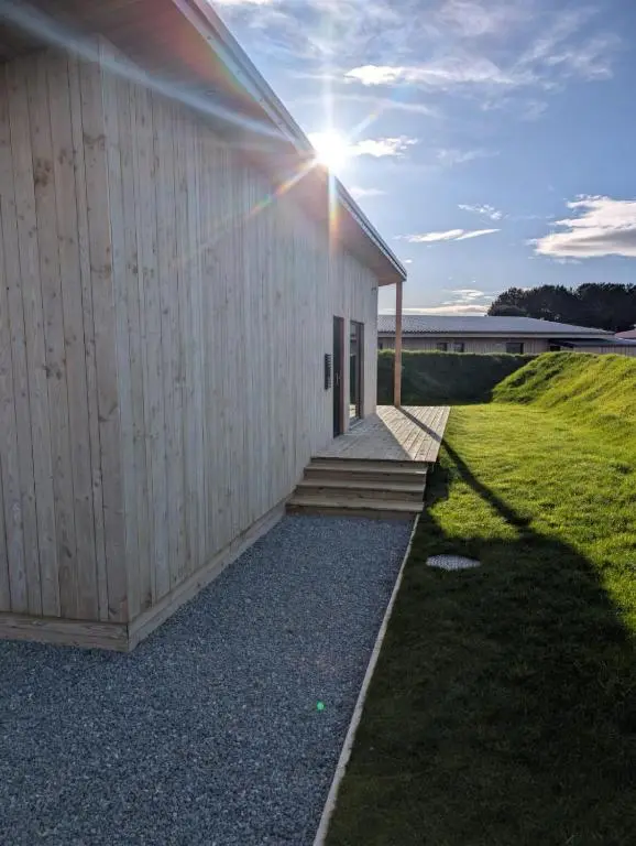 a building with the sun shining on the side of it at Luxury Lodge by Findhorn Sands No 18 in Findhorn