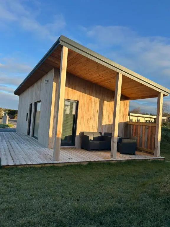 a building with a deck with a couch on it at Luxury Lodge by Findhorn Sands No 18 in Findhorn