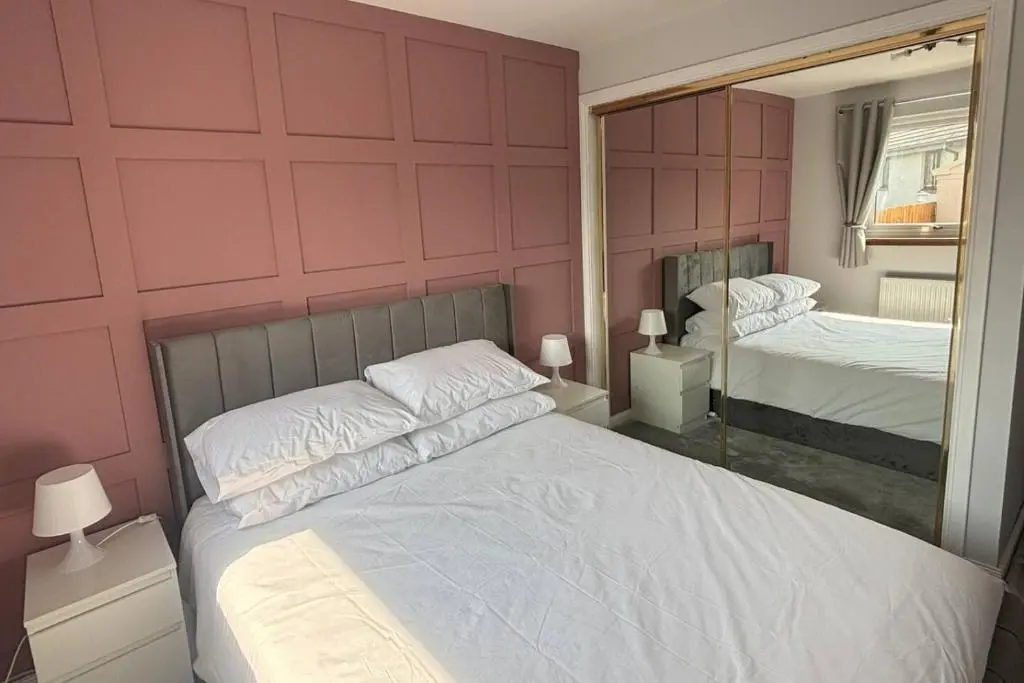a bedroom with a large bed and a mirror at The Burghead Hideaway in Burghead