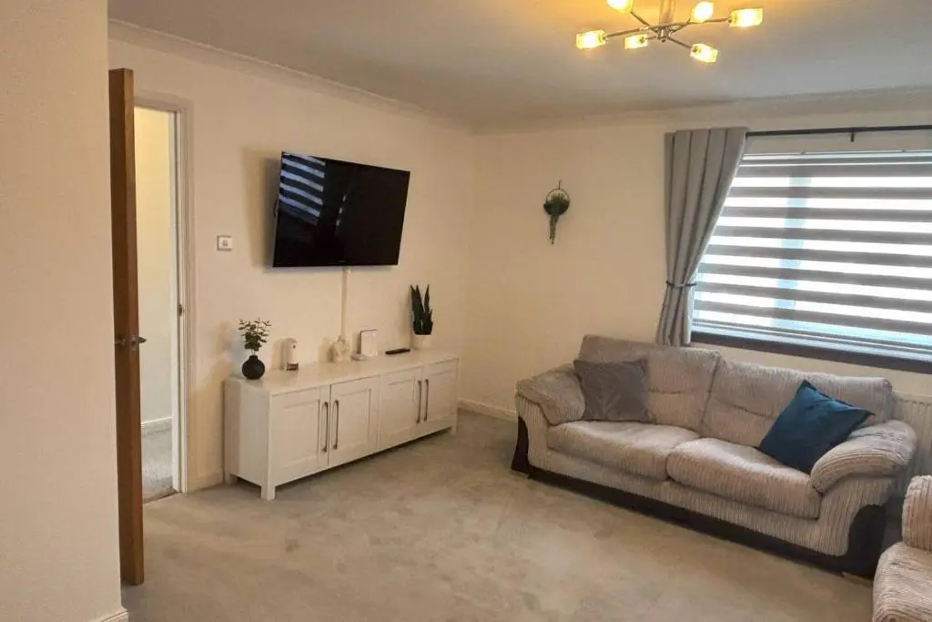 a living room with a couch and a flat screen tv at The Burghead Hideaway in Burghead