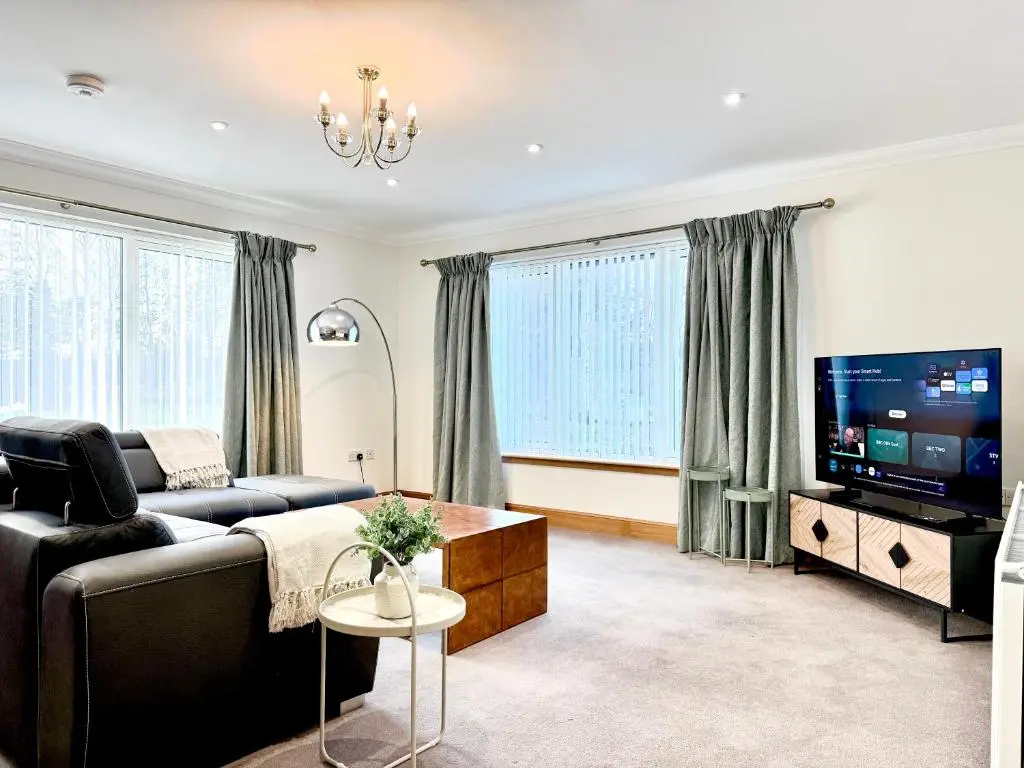a living room with a couch and a tv at Golf View Spacious Bungalow 2 Bathrooms, Free Parking WiFi in Elgin