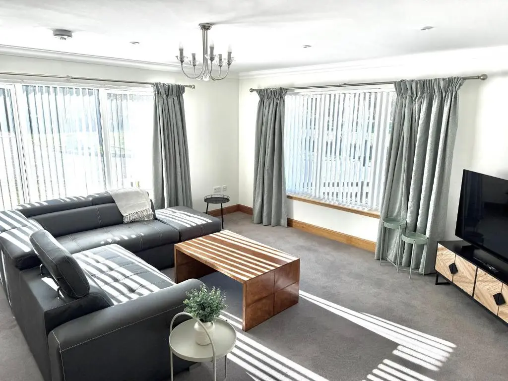 a living room with a couch and a tv at Golf View Spacious Bungalow 2 Bathrooms, Free Parking WiFi in Elgin