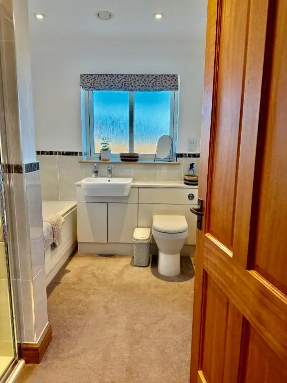 a bathroom with a sink and a toilet and a window at Golf View Spacious Bungalow 2 Bathrooms, Free Parking WiFi in Elgin