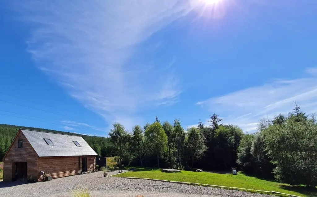a barn with the sun in the sky at Woodland studio in Stittenham