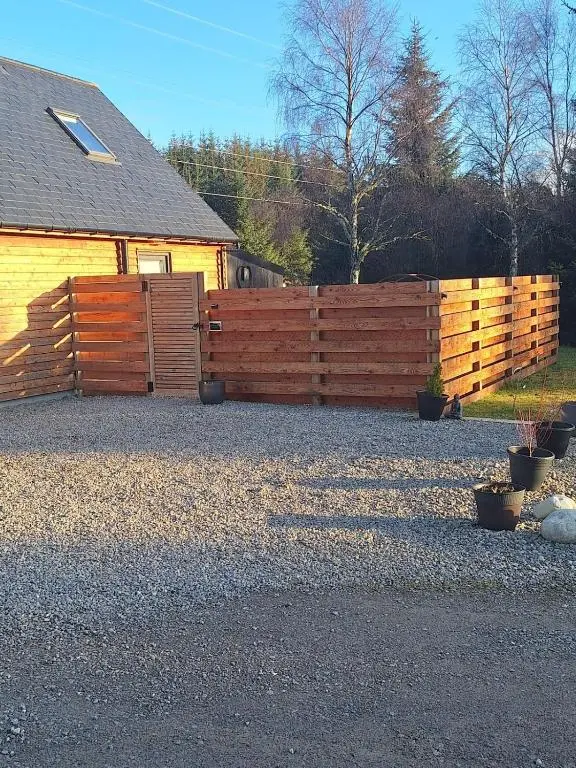 a wooden fence in front of a house at Woodland studio in Stittenham