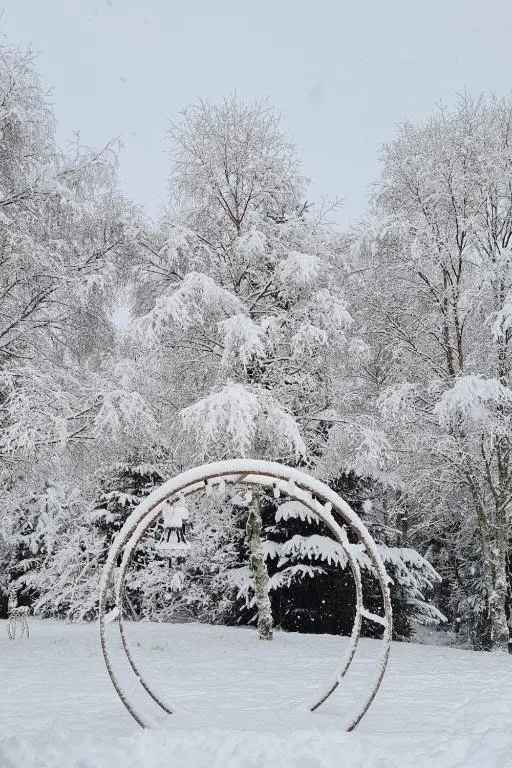 a snow covered sculpture in a park with trees at Woodland studio in Stittenham