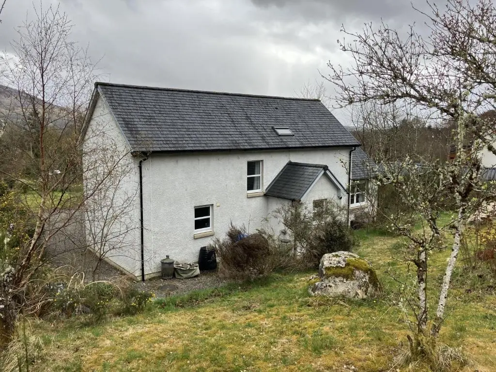 a white house with a black roof on a hill at Oiseval in Fort Augustus