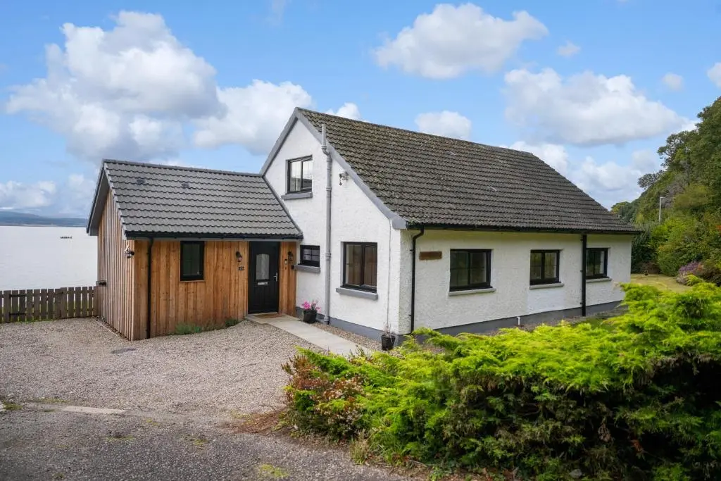 a white house with a black roof at Linden House in Fortrose