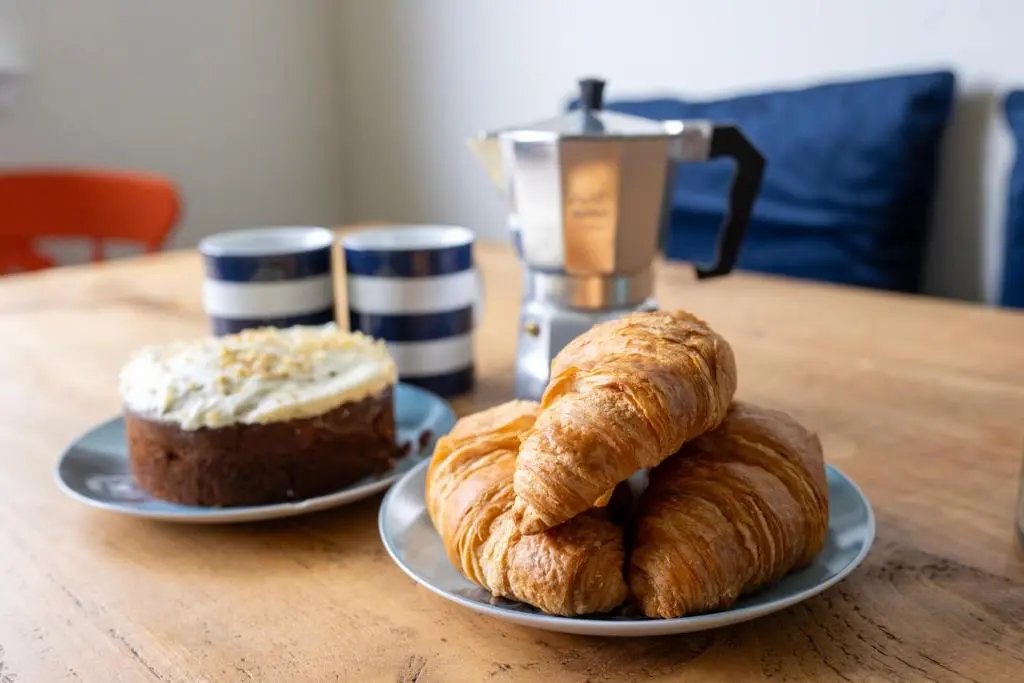 two plates of croissants and a cake on a table at Linden House in Fortrose