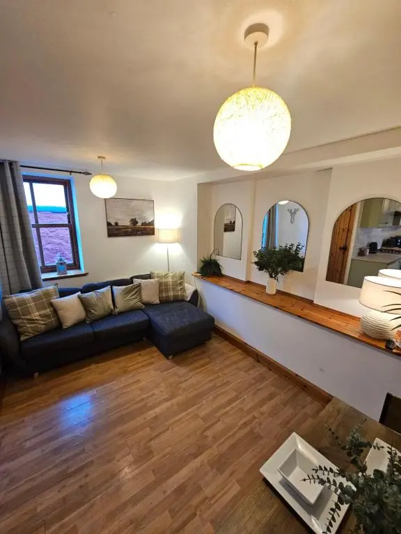 a living room with a couch and a table at The Saddlery Inverness in Dalneigh