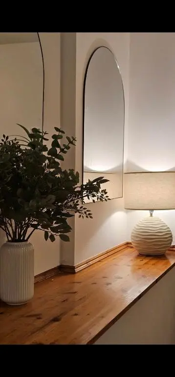 a room with a table with a plant and a lamp at The Saddlery Inverness in Dalneigh