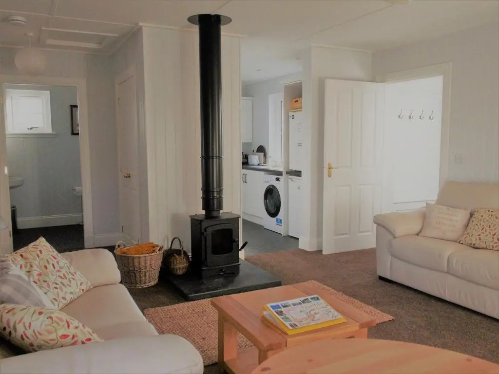 a living room with a stove in the middle of a room at Ardshiel in Foyers