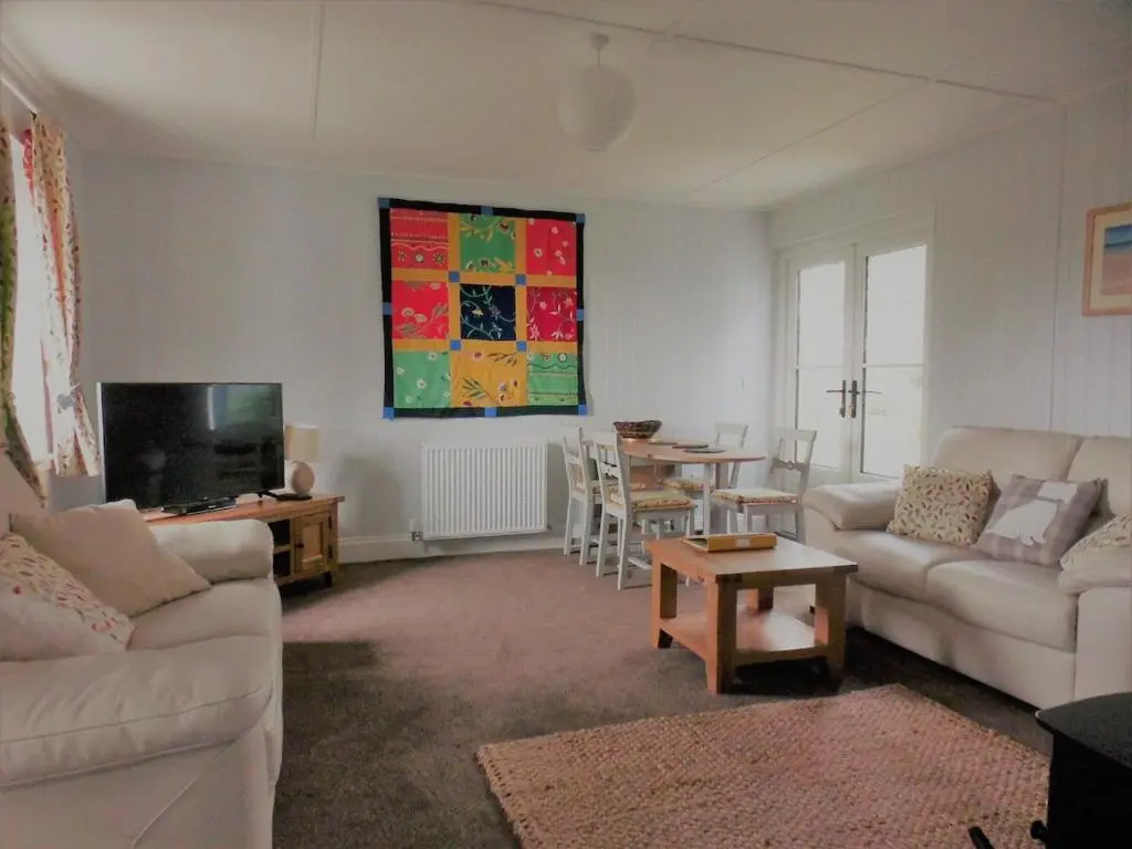 a living room with a couch and a tv and a table at Ardshiel in Foyers
