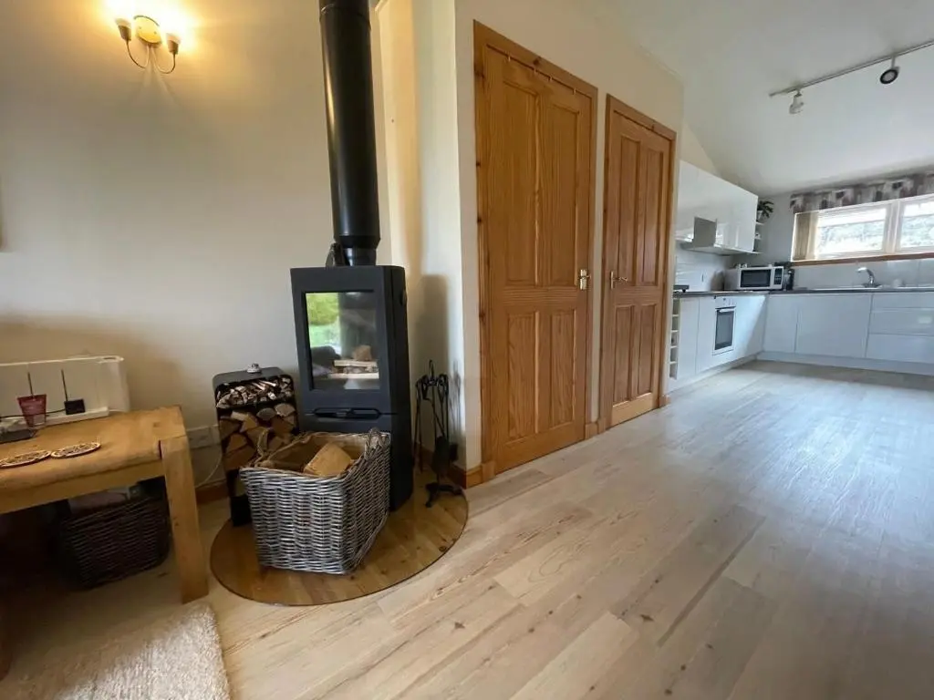 a living room with a wood stove in a room at Hopeman Cottages in Hopeman