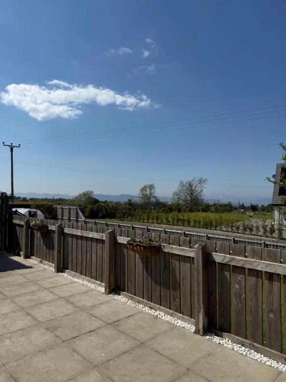 a wooden fence with flowers on it on a sidewalk at Culloden retreat in Culloden