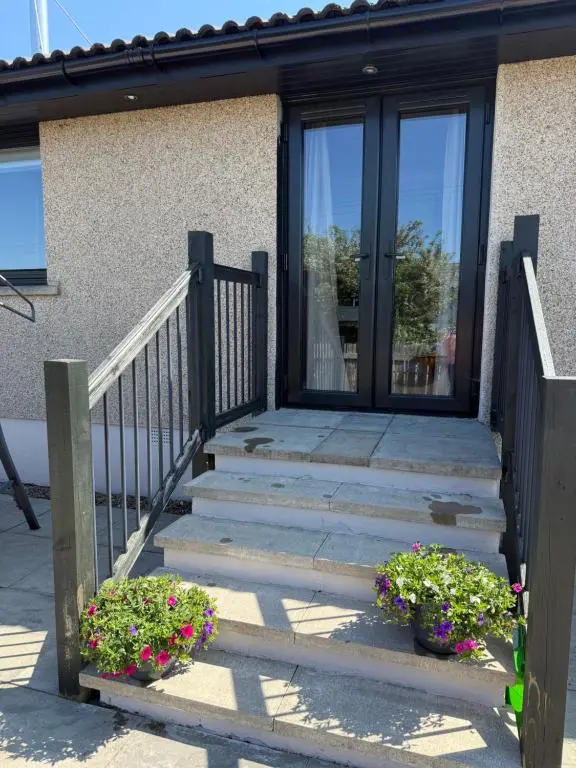 a staircase leading to a door of a house with flowers at Culloden retreat in Culloden
