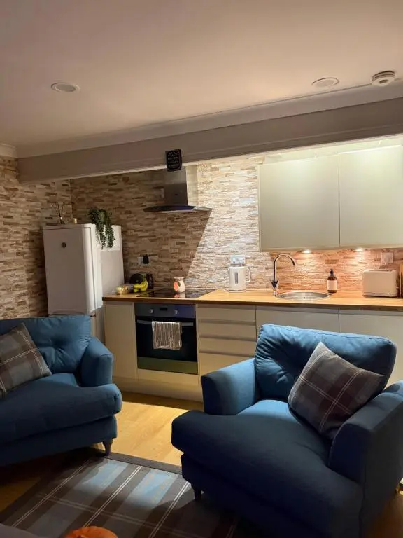 a kitchen with two blue couches in a living room at Culloden retreat in Culloden