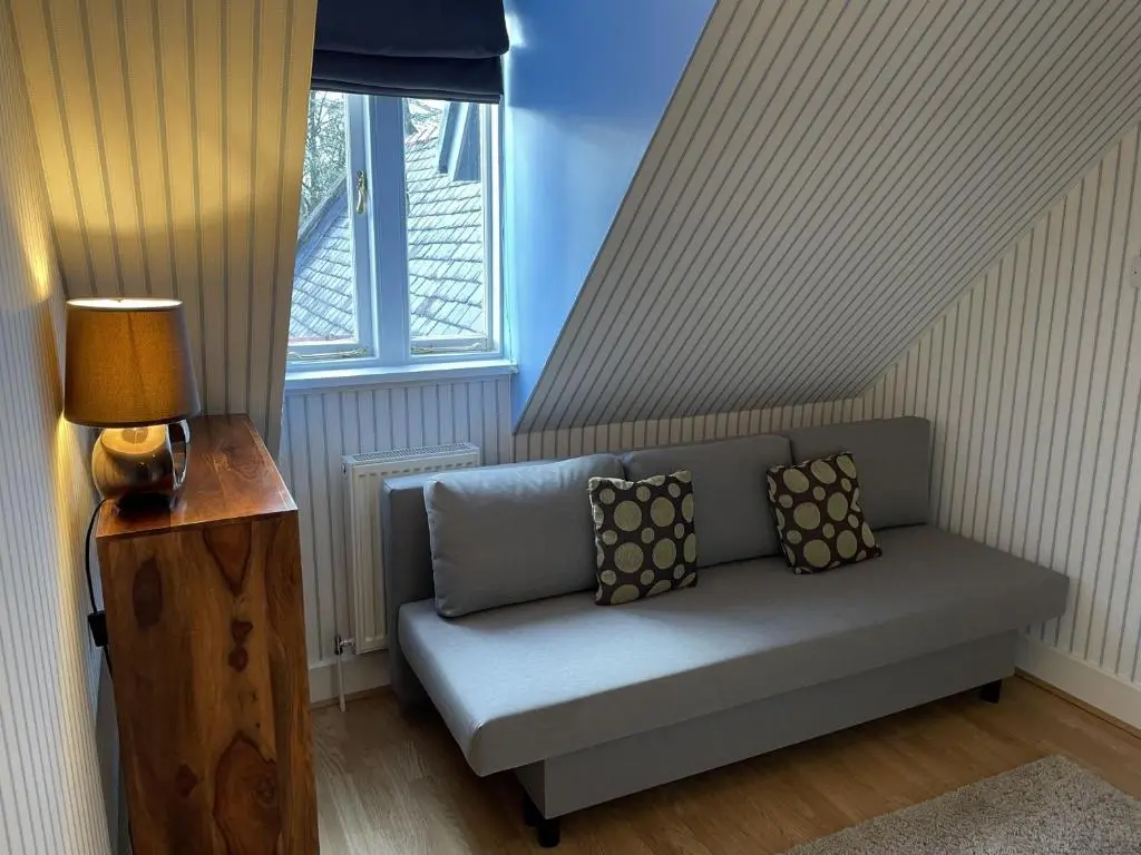 a couch sitting in a room with a window at Moat House 6 in Fort Augustus