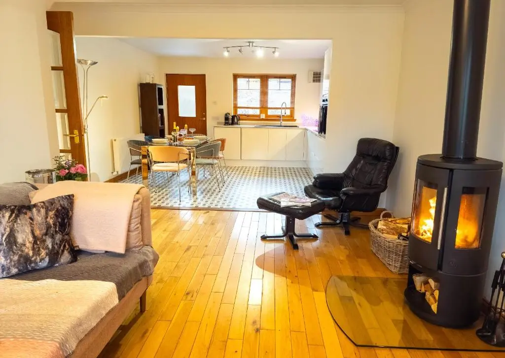 a living room with a wood stove in it at Casa Amor in Aviemore