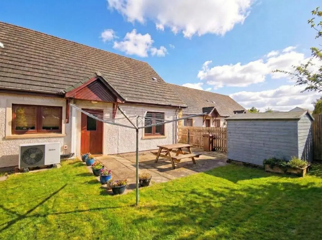 a backyard of a house with a picnic table at Casa Amor in Aviemore