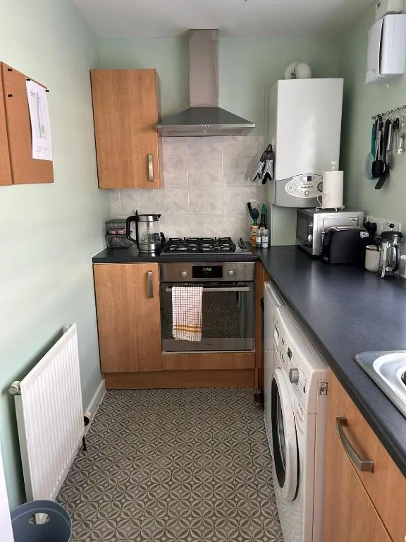 a kitchen with a stove and a washing machine at Cosy 1 bedroom ground floor flat, Central Inverness in Inverness