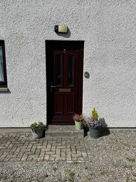 a door of a house with two potted plants at Cosy 1 bedroom ground floor flat, Central Inverness in Inverness