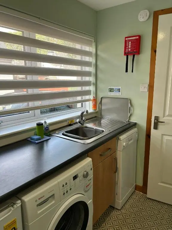 a kitchen with a sink and a washing machine at Cosy 1 bedroom ground floor flat, Central Inverness in Inverness