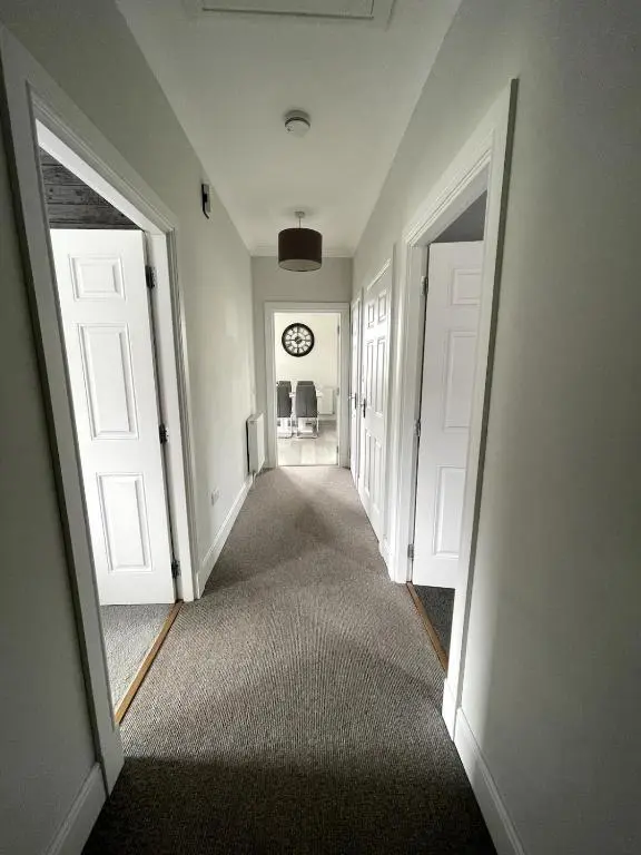 an empty hallway with two doors and a clock on the wall at Spacious Flat in Aberdeenshire in Insch