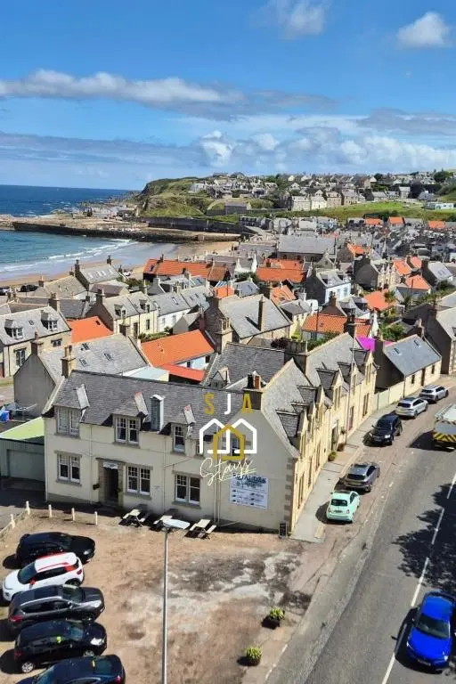 an aerial view of a town with cars parked at Beachside Cottage - SJA Stays - Modern 3 Bedroom House in Cullen