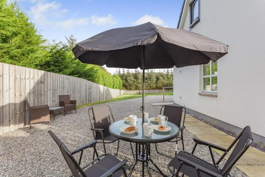 a table and chairs with an umbrella on a patio at 1 Bed in Daviot oc-c33520 in Daviot