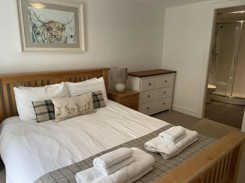 a bedroom with a bed with towels on it at Raven Wing 11 - Kintail Apartment in Fort Augustus