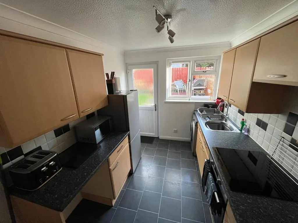 a small kitchen with a sink and a refrigerator at 26 Two bedroom apt with private garden in Culloden