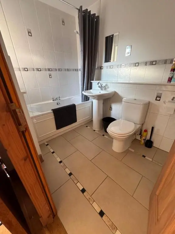 a bathroom with a tub and a toilet and a sink at Church Street Apartment in Inverness