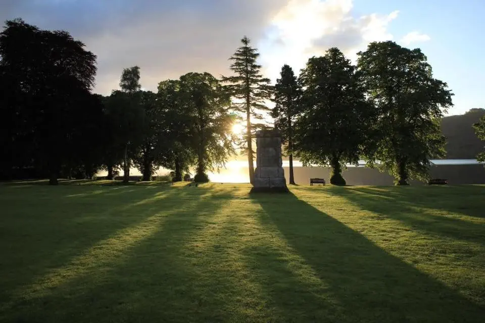 a grass field with trees and the sun in the background at Raven Wing 17 - Aonach Mor in Fort Augustus