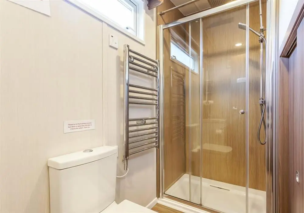 a bathroom with a glass shower and a toilet at Loch Ness Highland Resort in Fort Augustus