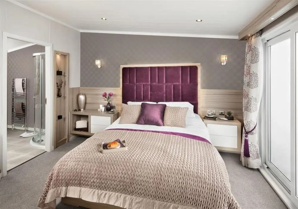 a bedroom with a large bed with a purple headboard at Loch Ness Highland Resort in Fort Augustus