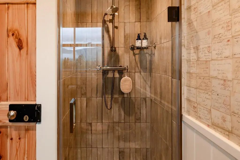 a shower with a glass door in a bathroom at Garradh Cottage - Seasgair Lodges in Kincraig