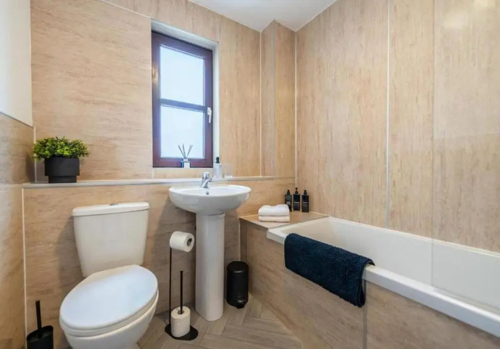 a bathroom with a toilet and a sink and a tub at Bright & Spacious 2BR Fraserburgh for Work & Family Stays in Fraserburgh