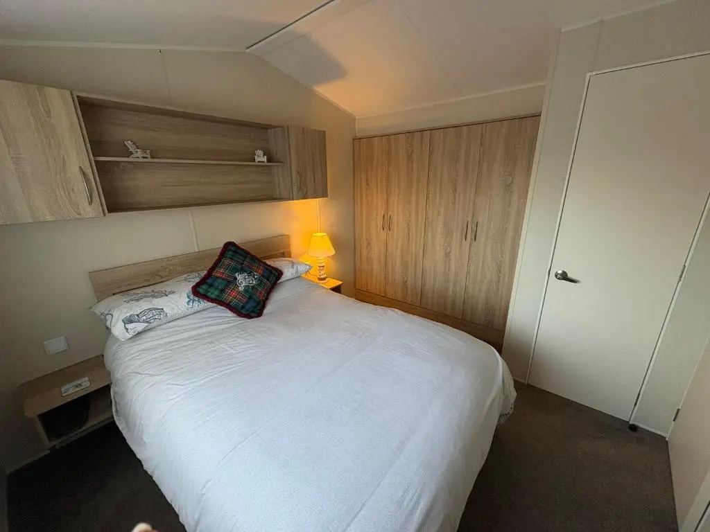 a bedroom with a bed with a pillow on it at Pebble Cove 74 in Lossiemouth