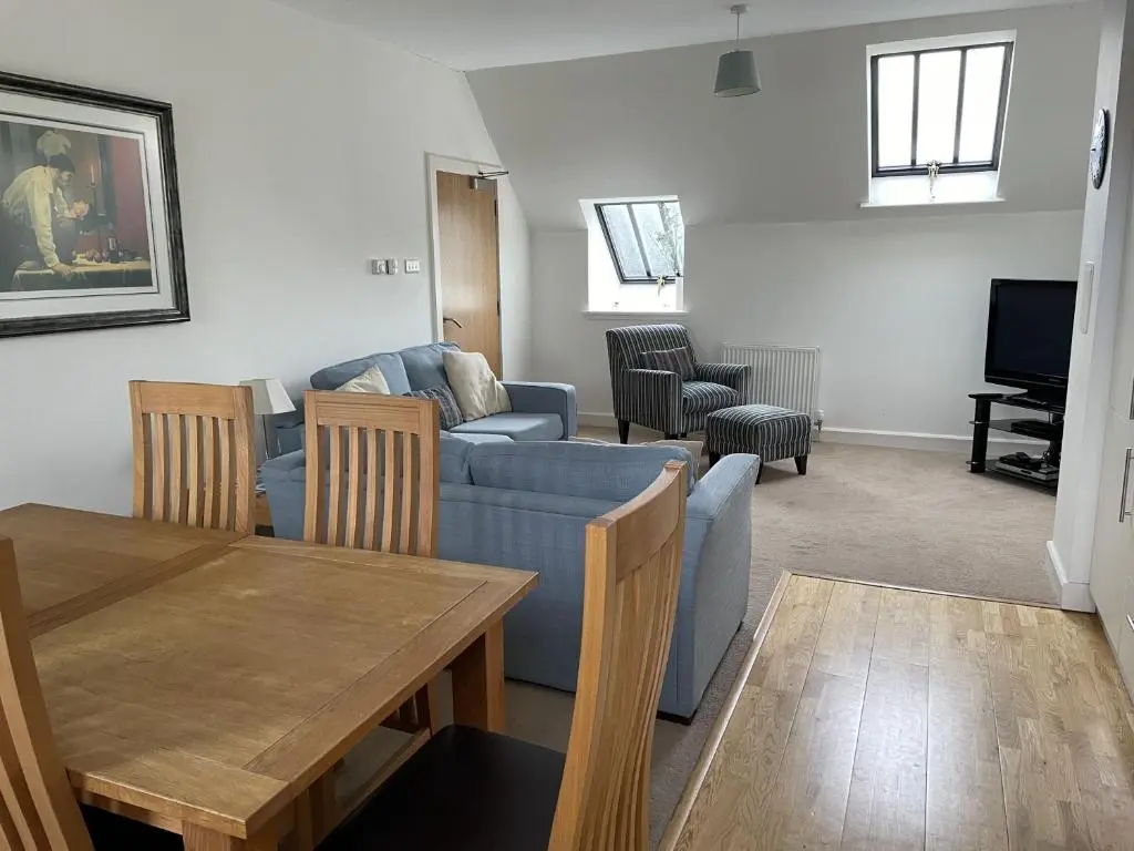 a living room with a blue couch and a table at Monastery 17 in Fort Augustus