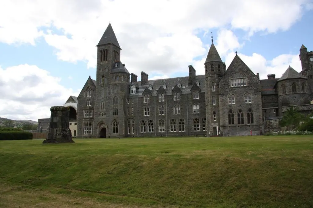 an old castle with a grass field in front of it at Monastery 17 in Fort Augustus